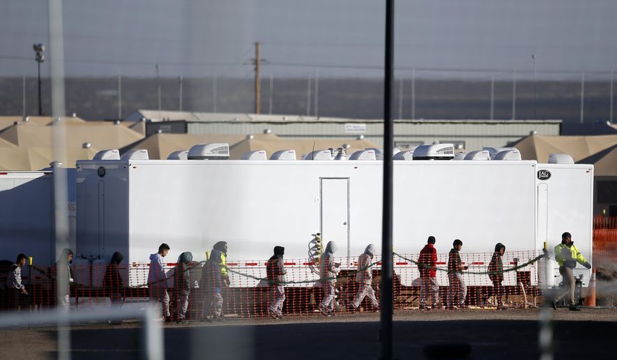 FILE - In this Dec. 13, 2018 file photo migrant teens walk in a line through the Tornillo detention camp in Tornillo, Texas. The Trump administration says it will keep the tent city holding more than 2,000 migrant teenagers open through early 2019. The announcement was made Wednesday, Dec. 26, 2018 about the Tornillo facility, which opened in June in an isolated corner of the Texas desert for up to 360 children. (AP Photo/Andres Leighton, file)