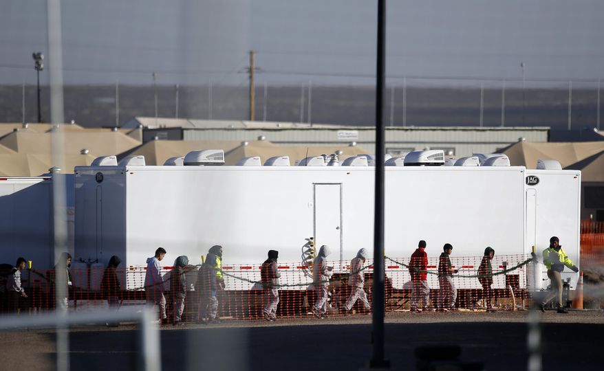 FILE - In this Dec. 13, 2018 file photo migrant teens walk in a line through the Tornillo detention camp in Tornillo, Texas. The Trump administration says it will keep the tent city holding more than 2,000 migrant teenagers open through early 2019. The announcement was made Wednesday, Dec. 26, 2018 about the Tornillo facility, which opened in June in an isolated corner of the Texas desert for up to 360 children. (AP Photo/Andres Leighton, file)