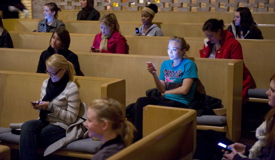 In this Dec. 14, 2009 photo, Stephens College students send a text to the college president before turning the phones off and turning them in during vespers on the college campus in Columbia, Mo. On a bitter cold December night, with the start of final exams just hours away, Stephens students grudgingly piled their cell phones into collection baskets and filed into the school's chapel for the first of what Lynch hopes are regular vespers.(AP Photo/L.G. Patterson)