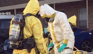 In this Thursday, Oct. 27, 2016, file photo provided by the U.S. Drug Enforcement Agency, members of the DEA Hazardous Materials/Clandestine Laboratory Enforcement Team go through a decontamination procedure in Lubbock, Texas. During the operation, substances were seized during an ongoing investigation of fentanyl and fentanyl-related compounds. (Russ Baer/DEA via AP) ** FILE **