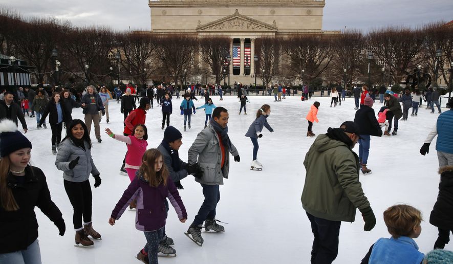 People skate on the National Gallery of Art Sculpture Garden Ice Rink, Thursday, Dec. 27, 2018, as a partial government shutdown continues in Washington. The museum and the skate rink will be closed to the public after January 2nd as a result of the shutdown if it continues into the new year. Behind the rink is the National Archives, which is closed due to the shutdown. President Donald Trump has vowed to hold the line on his budget demand, telling reporters during his visit to Iraq Wednesday that he'll do "whatever it takes" to get money for border security. The White House and congressional Democrats have been talking but to little effect. (AP Photo/Jacquelyn Martin)