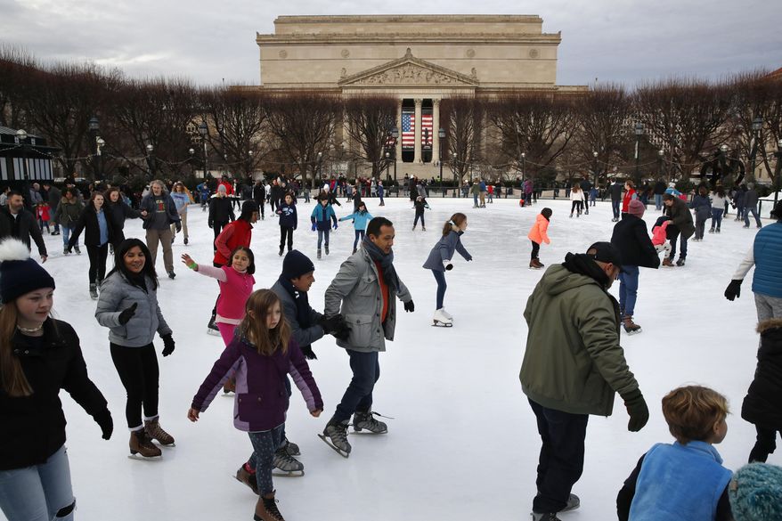 People skate on the National Gallery of Art Sculpture Garden Ice Rink, Thursday, Dec. 27, 2018, as a partial government shutdown continues in Washington. The museum and the skate rink will be closed to the public after January 2nd as a result of the shutdown if it continues into the new year. Behind the rink is the National Archives, which is closed due to the shutdown. President Donald Trump has vowed to hold the line on his budget demand, telling reporters during his visit to Iraq Wednesday that he'll do "whatever it takes" to get money for border security. The White House and congressional Democrats have been talking but to little effect. (AP Photo/Jacquelyn Martin)