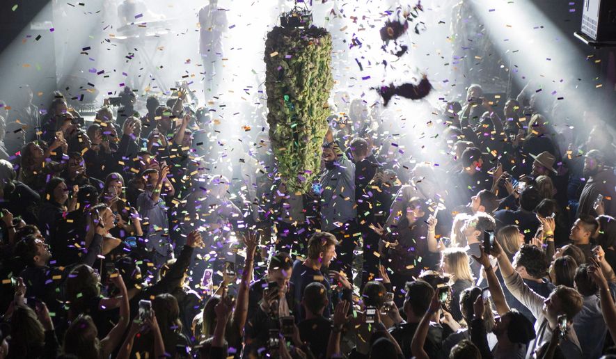 In this Oct. 17, 2018, file photo a depiction of a cannabis bud drops from the ceiling at Leafly's countdown party in Toronto as midnight passes and marks the first day of the legalization of cannabis across Canada. The last year was a 12-month champagne toast for the legal marijuana industry as the global market exploded and cannabis pushed its way further into the financial and cultural mainstream. Canada ushered in broad legalization, U.S. drug regulators approved the first cannabis-based drug and investors pumped in billions of dollars. (Chris Young/The Canadian Press via AP, File)