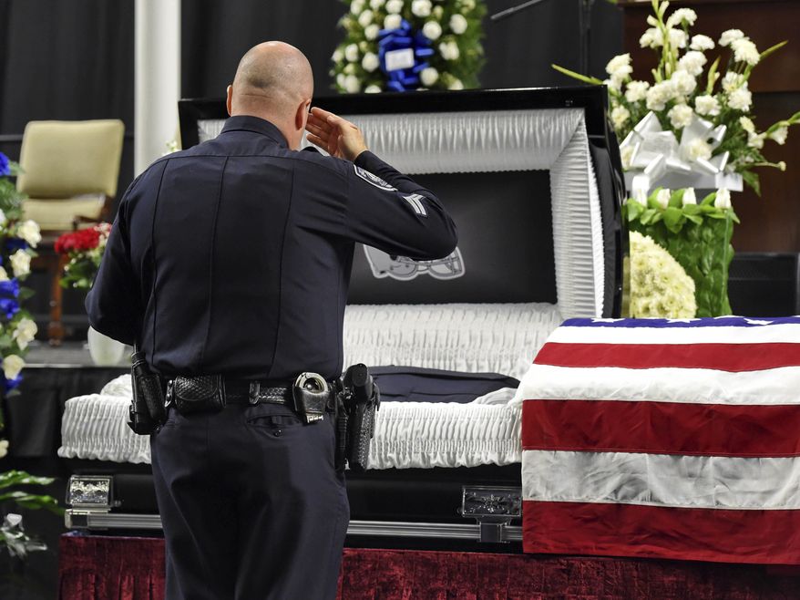 FILE - In this Oct. 8, 2018, file photo, mourners and police officers from around the country attend a memorial service before the funeral for fallen Florence police officer Sgt. Terrence Carraway at the Florence Center in Florence, S.C. Sgt. Carraway was killed in the line of duty Wednesday, Oct. 3, 2018. More police officers have died in the line of duty this year than in 2017. That's according to data compiled by the National Law Enforcement Officers Memorial Fund. The organization said in a report Thursday that 144 federal, state and local officers have died so far in 2018. That's up from the 129 who died last year. (AP Photo/Richard Shiro, File)