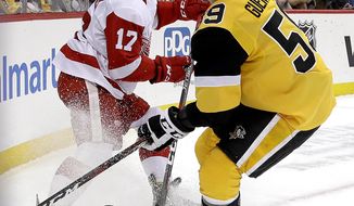 Detroit Red Wings&#39; Filip Hronek (17) clears the puck before Pittsburgh Penguins&#39; Jake Guentzel (59) can get his stick on it during the second period of an NHL hockey game in Pittsburgh, Thursday, Dec. 27, 2018. (AP Photo/Gene J. Puskar)