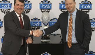 Virginia head coach Bronco Mendenhall, right, and South Carolina head coach Will Muschamp, left, pose for a photo during media day for the Belk Bowl NCAA college football game in Charlotte, N.C., Friday, Dec. 28, 2018. Virginia plays South Carolina on Saturday, Dec. 29, 2018. (AP Photo/Steve Reed)