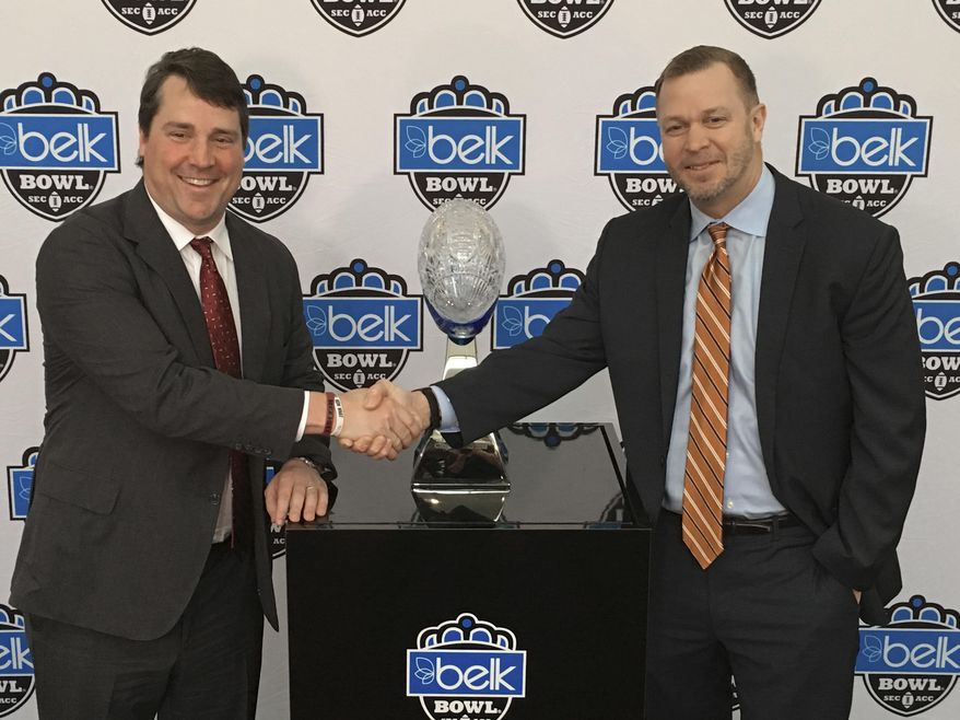 Virginia head coach Bronco Mendenhall, right, and South Carolina head coach Will Muschamp, left, pose for a photo during media day for the Belk Bowl NCAA college football game in Charlotte, N.C., Friday, Dec. 28, 2018. Virginia plays South Carolina on Saturday, Dec. 29, 2018. (AP Photo/Steve Reed)