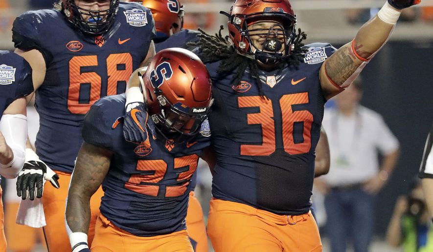 Syracuse fullback Chris Elmore (36) celebrates with running back Abdul Adams (23) after Adams scored a touchdown on a 3-yard run against West Virginia during the first half of the Camping World Bowl NCAA college football game Friday, Dec. 28, 2018, in Orlando, Fla. (AP Photo/John Raoux)
