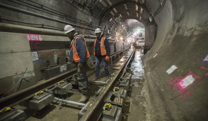 In this Nov. 29, 2018 photo, a construction crew works on the tracks of the East Side Access project beneath Grand Central Terminal in New York. The super-pricey railroad hub is taking shape, dogged by billion-dollar cost overruns and a decade of delays, but still impressive as an engineering marvel. (AP Photo/Mary Altaffer)
