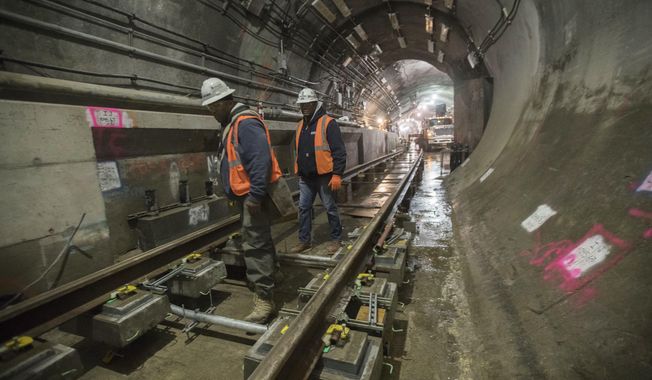 In this Nov. 29, 2018 photo, a construction crew works on the tracks of the East Side Access project beneath Grand Central Terminal in New York. The super-pricey railroad hub is taking shape, dogged by billion-dollar cost overruns and a decade of delays, but still impressive as an engineering marvel. (AP Photo/Mary Altaffer)