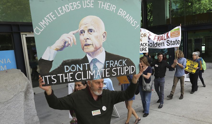 FILE - In this May 19, 2014, file photo, Richard Gray joins others in a demonstration calling on Gov. Jerry Brown to end hydraulic fracturing for oil and gas, before Brown&#39;s appearance before the University of California Giannini Foundation of Agricultural Economics conference in Sacramento, Calif. While Brown has made significant strides on climate change programs, critics fault him for failing to stop new oil drilling. Brown leaves office Jan. 7, 2019, after a record four terms in office, from 1975-1983 and again since 2011. (AP Photo/Rich Pedroncelli, File)