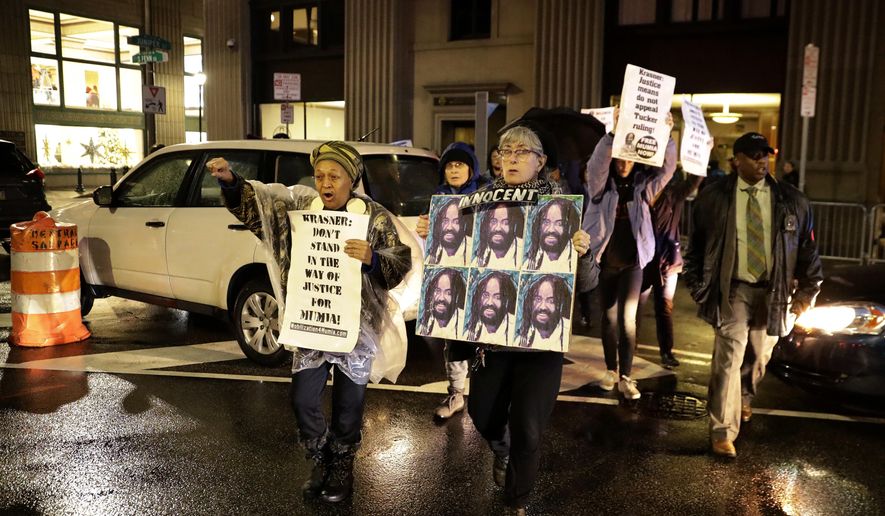 Protestors walk on Broad Street to demonstrate for Mumia Abu-Jamal outside the offices of District Attorney Larry Krasner, Friday, Dec. 28, 2018, in Philadelphia. A judge issued a split ruling Thursday that grants Abu-Jamal another chance to appeal his 1981 conviction in a Philadelphia police officer&#x27;s death. (AP Photo/Matt Slocum)