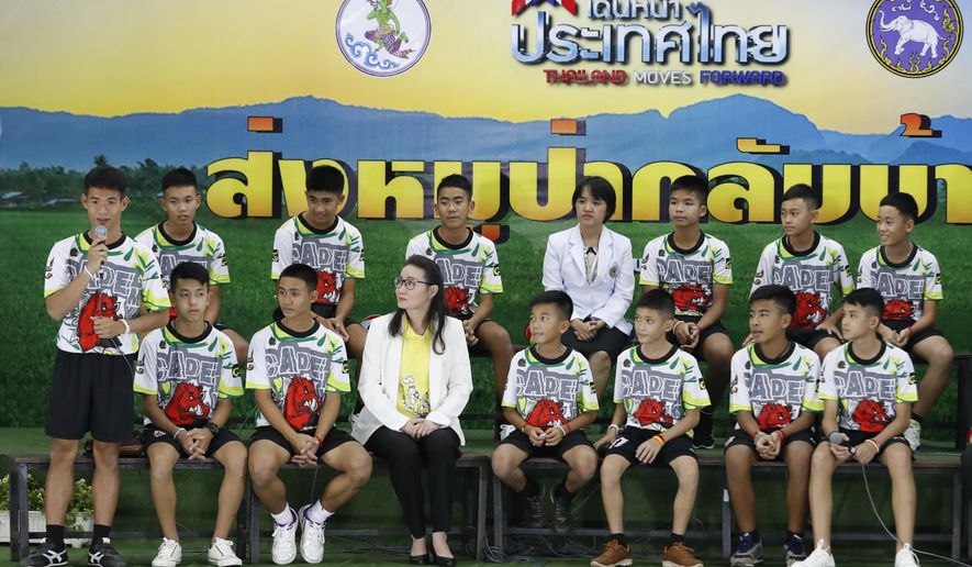 FILE - In this file photo dated Wednesday, July 18, 2018, Coach&amp;quot; Ake&amp;quot; Ekkapol Janthawong, left, speaks on behalf of the 12 boys and himself about their rescue from a flooded cave during a press conference discussing their ordeal in Chiang Rai, northern Thailand.  The British divers who helped rescue young soccer players trapped in a flooded cave in Thailand are among those being recognized in Britain’s New Year’s Honors List, according to the list of recipients released Friday Dec. 28, 2018. (AP Photo/Vincent Thian, FILE)