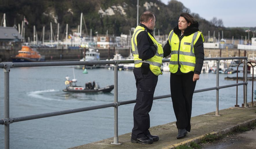 Britain's Immigration Minister Caroline Nokes talks to a Border Force officer as a Border Force RIB passes in the harbour, in Dover, England, to discuss recent attempts by migrants to reach Britain by small boats, Saturday Dec. 29, 2018. Home Secretary Sajid Javid is cutting short a family holiday to help deal with the "major incident" of a rising number of migrants attempting to cross the English Channel by boat from northern France. (Victoria Jones/PA via AP)