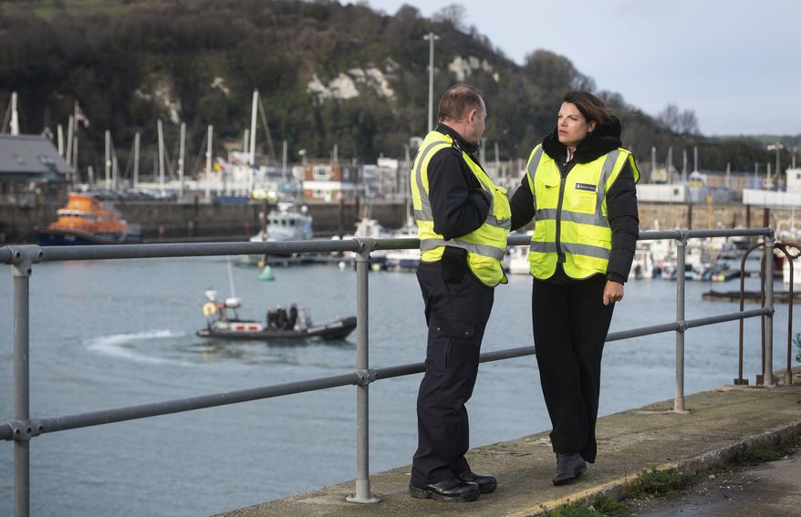 Britain's Immigration Minister Caroline Nokes talks to a Border Force officer as a Border Force RIB passes in the harbour, in Dover, England, to discuss recent attempts by migrants to reach Britain by small boats, Saturday Dec. 29, 2018. Home Secretary Sajid Javid is cutting short a family holiday to help deal with the "major incident" of a rising number of migrants attempting to cross the English Channel by boat from northern France. (Victoria Jones/PA via AP)