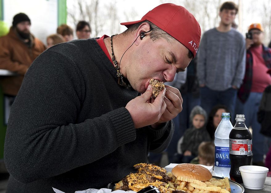 YouTube star and professional eater Randy Santel bites into a portion of KC Finn's Big A** Burger as he took on the challenge, Wednesday, December 26, in Jackson, Tenn. Santel finished the challenge, which included a 5lb burger, 1lb of fries and a drink, in 12:44. (Kenneth Cummings/The Jackson Sun via AP)