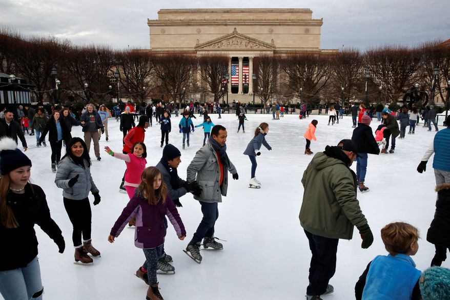 People skate on the National Gallery of Art Sculpture Garden Ice Rink, Thursday, Dec. 27, 2018, as a partial government shutdown continues in Washington. The museum and the skate rink will be closed to the public after January 2nd as a result of the shutdown if it continues into the new year. Behind the rink is the National Archives, which is closed due to the shutdown. President Donald Trump has vowed to hold the line on his budget demand, telling reporters during his visit to Iraq Wednesday that he&#39;ll do &quot;whatever it takes&quot; to get money for border security. The White House and congressional Democrats have been talking but to little effect. (AP Photo/Jacquelyn Martin)