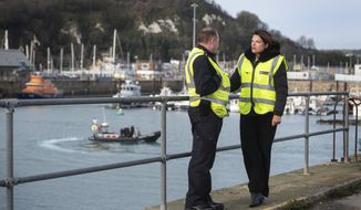 Britain&#39;s Immigration Minister Caroline Nokes talks to a Border Force officer as a Border Force RIB passes in the harbour, in Dover, England, to discuss recent attempts by migrants to reach Britain by small boats, Saturday Dec. 29, 2018.  Home Secretary Sajid Javid is cutting short a family holiday to help deal with the &amp;quot;major incident&amp;quot; of a rising number of migrants attempting to cross the English Channel by boat from northern France. (Victoria Jones/PA via AP)