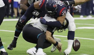 Houston Texans defensive end Christian Covington (95) hits Jacksonville Jaguars quarterback Blake Bortles (5) causing a fumble during the first half of an NFL football game, Sunday, Dec. 30, 2018, in Houston. Jacksonville recovered the ball. (AP Photo/David J. Phillip)