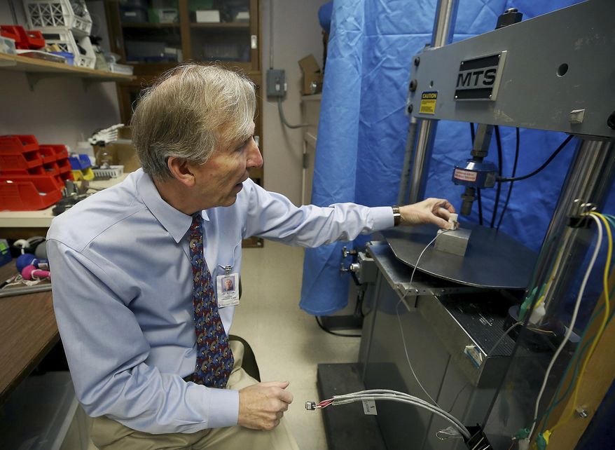In this Dec. 17, 2018 photo, John Szivek, Rubin chair in orthopedic research professor at the University of Arizona, explains how the scaffold made from a 3-D printer is tested in Tucson, Ariz. Szivek received a $2 million grant from the U.S. Department of Defense to develop technology that could help military personnel recover from bone-shattering injuries using a 3-D printer and adult stem cells. (Mamta Popat /Arizona Daily Star via AP)