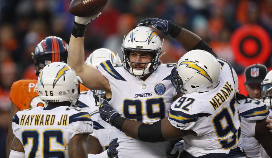 Los Angeles Chargers defensive end Joey Bosa, center, reacts with teammates after recovering a fumble during the second half of an NFL football game against the Denver Broncos, Sunday, Dec. 30, 2018, in Denver. (AP Photo/David Zalubowski)