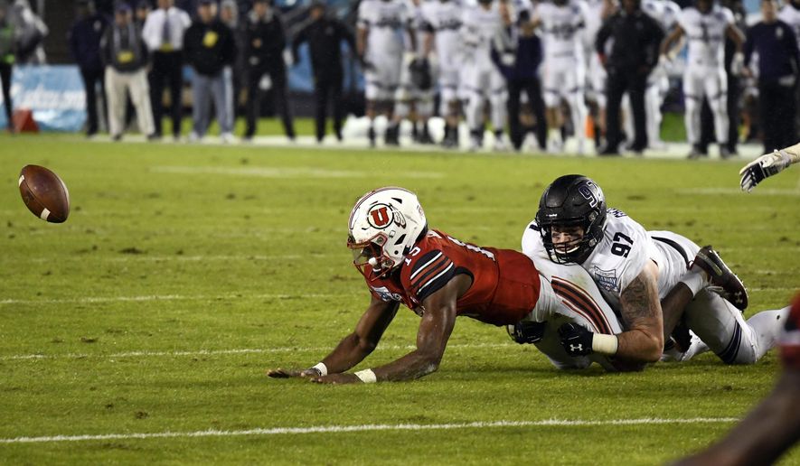 Utah quarterback Jason Shelley (15) fumbles as he is tackled by Northwestern defensive lineman Joe Gaziano (97) as he runs during the second half of the Holiday Bowl NCAA college football game Monday, Dec. 31, 2018, in San Diego. The fumble was picked up by Northwestern and returned for an 86-yard touchdown. (AP Photo/Denis Poroy)