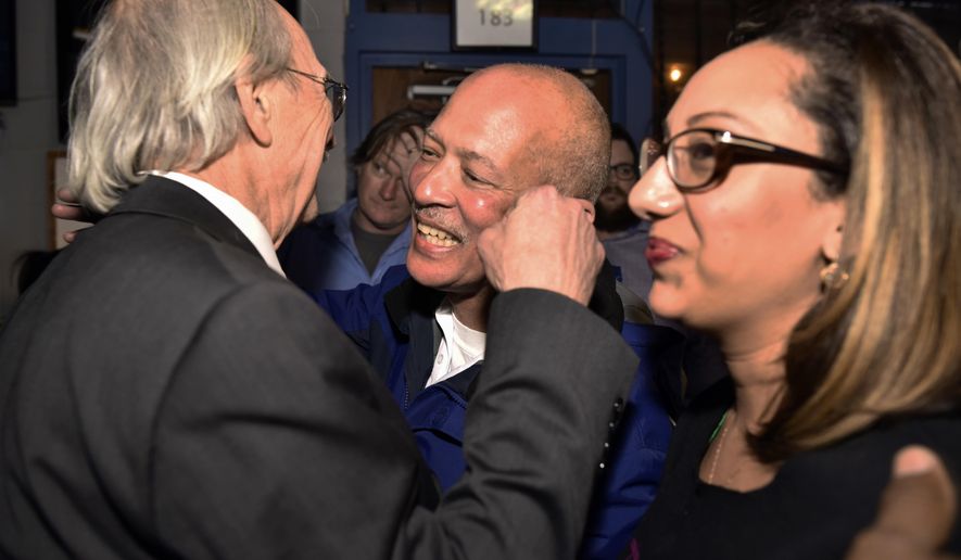 FILE - In this March, 6, 2018, file photo, Dallas District Attorney John Creuzot, center, is congratulated as he enters an election watch party for the Dallas County Democrats at Dallasite bar and billiards in Dallas, Texas. Creuzot won after promising to reduce incarceration rates by 15 percent to 20 percent and to treat drug crimes as a public health issue. (Ben Torres/The Dallas Morning News via AP)