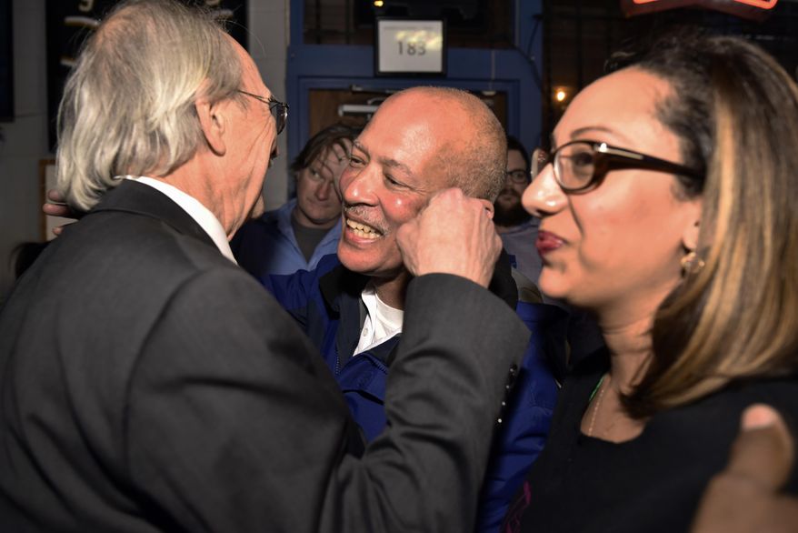 FILE - In this March, 6, 2018, file photo, Dallas District Attorney John Creuzot, center, is congratulated as he enters an election watch party for the Dallas County Democrats at Dallasite bar and billiards in Dallas, Texas. Creuzot won after promising to reduce incarceration rates by 15 percent to 20 percent and to treat drug crimes as a public health issue. (Ben Torres/The Dallas Morning News via AP)
