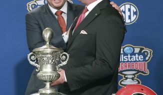 Georgia head coach Kirby Smart, right, and Texas head coach Tom Herman laugh during their photo opportunity with the Sugar Bowl trophy at a press conference on Monday, Dec 31, 2018, in New Orleans. No. 14 Texas will try to cap an impressive season when it faces No. 6 Georgia in the Sugar Bowl on Tuesday night, Jan. 1, 2019. (Curtis Compton/Atlanta Journal-Constitution via AP)
