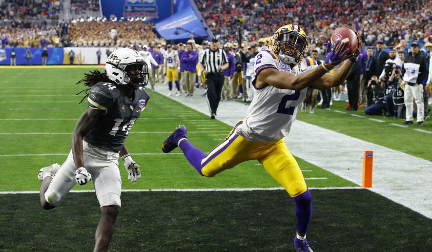 LSU wide receiver Justin Jefferson (2) makes a touchdown catch against UCF defensive back Nevelle Clarke (14) during the first half of a Fiesta Bowl NCAA college football game Tuesday, Jan. 1, 2019, in Glendale, Ariz. (AP Photo/Ross D. Franklin)