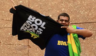 A supporter shows a T-shirt with the name of the Brazil&#39;s President-elect Jair Bolsonaro, prior to Bolsonaro&#39;s Tuesday&#39;s inauguration ceremony, in Brasília, Brazil, Monday, Dec. 31, 2018. The Secretary of Public Security in Brasilia said that they are expecting as many as 500,000 people to attend the ceremony. (AP Photo/Raimundo Pacco)