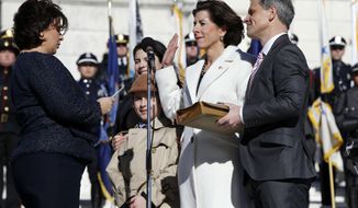 Rhode Island Gov. Gina Raimondo, second from right, takes the oath of office accompanied by her husband Andy, right, and two children Tommy, second from left, and Ceci, behind left, at the State House in Providence, R.I., Tuesday, Jan. 1, 2019. Raimondo was sworn into a second term in office, promising to continue bringing change to set the state on a &amp;quot;path for enduring success.&amp;quot; (AP Photo/Michael Dwyer)