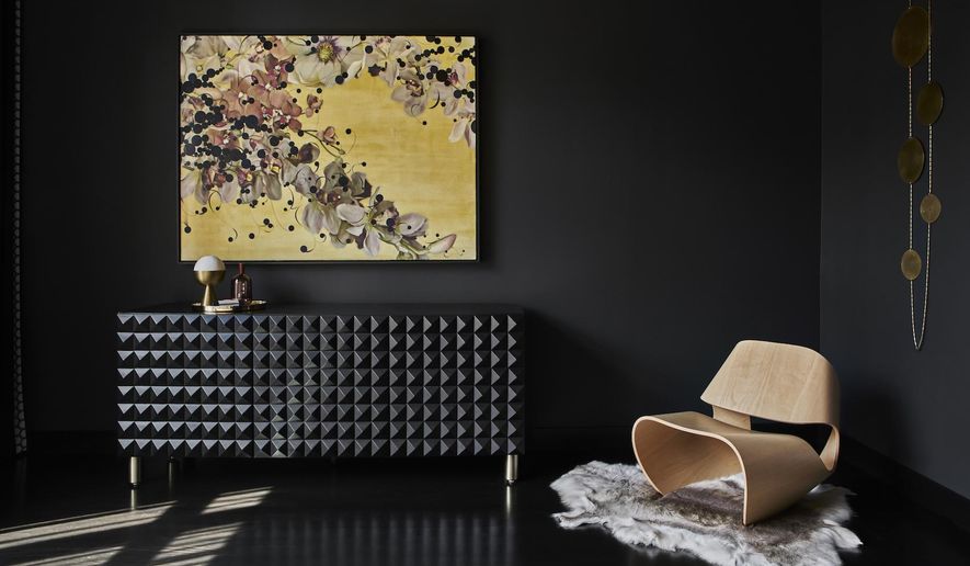 This photos shows how Studio Gild painted the walls of this Chicago home in Benjamin Moore's Midnight. "We wanted to create a space that's calming and cozy," says Kristen Ekeland. A black sideboard from SABIN adds depth, texture and drama. (Mike Schwartz/Studio Gild via AP)