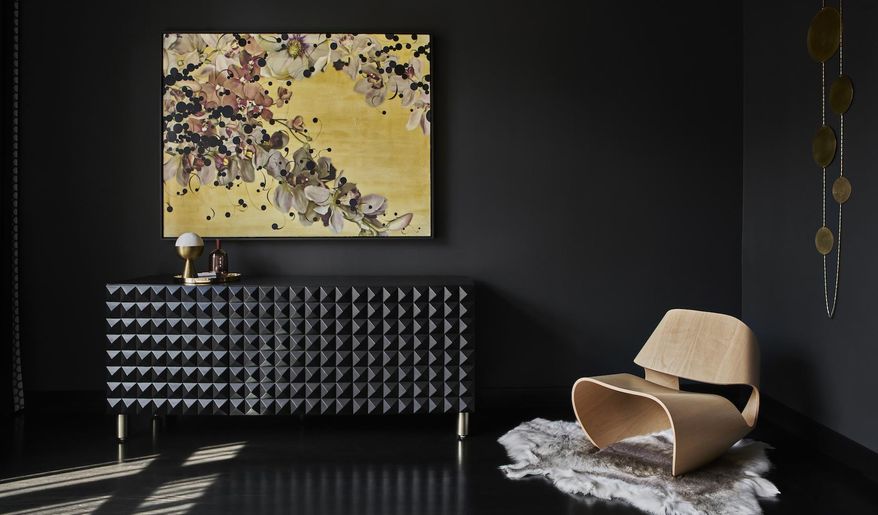 This photos shows how Studio Gild painted the walls of this Chicago home in Benjamin Moore's Midnight. "We wanted to create a space that's calming and cozy," says Kristen Ekeland. A black sideboard from SABIN adds depth, texture and drama. (Mike Schwartz/Studio Gild via AP)