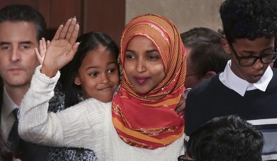 Rep. Ilhan Omar, center, a freshman Democrat representing Minnesota's 5th Congressional District, is sworn in on the House floor by new House Speaker Nancy Pelosi on the first day of the 116th Congress, Thursday, Jan. 3, 2019, at the Capitol in Washington,. (Glen Stubbe/Star Tribune via AP)