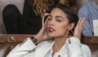 Rep. Alexandria Ocasio-Cortez, D-N.Y., holds a hair clip between her teeth as she pulls her hair back, on the opening day of the 116th Congress, at the Capitol in Washington, Thursday, Jan. 3, 2019. (AP Photo/J. Scott Applewhite) ** FILE **