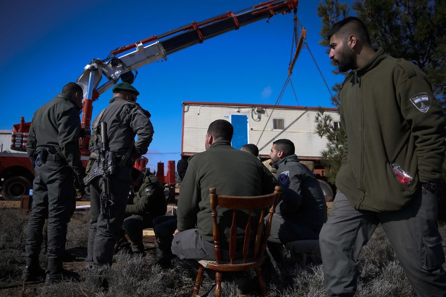 Israeli forces remove a caravan from the West Bank settlement outpost of Amona, Thursday, Jan. 3, 2019. The outpost was evacuated two years ago but a small group of settlers returned there in protest recently amid an outburst of Palestinian violence. (AP Photo/Ariel Schalit)