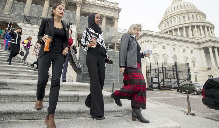 Rep. Alexandria Ocasio-Cortez, D-N.Y., left, and Rep. Ilhan Omar, D-Minn., second from left, walk down the House steps to take a group photograph of the House Democratic women members of the 116th Congress on the East Front Capitol Plaza on Capitol Hill in Washington, Friday, Jan. 4, 2019, as the 116th Congress begins. (AP Photo/Andrew Harnik)