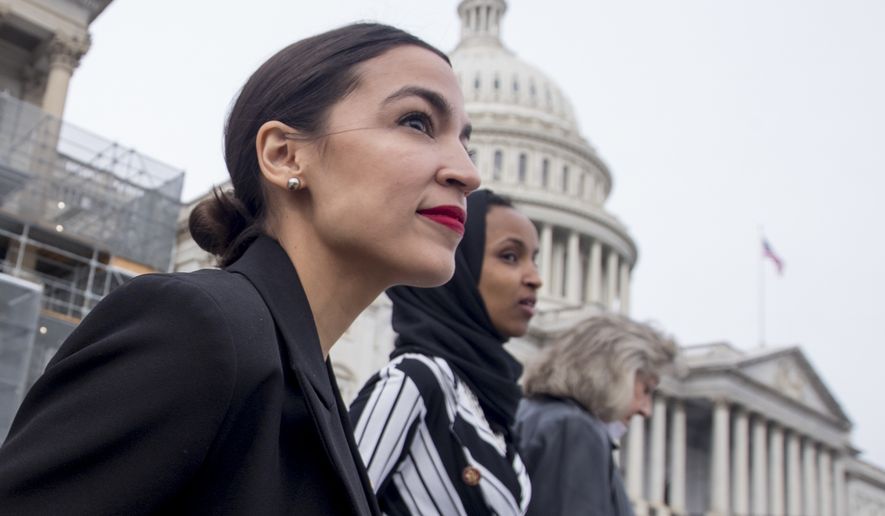 Rep. Alexandria Ocasio-Cortez, left, and D-N.Y., Rep. Ilhan Omar, D-Minn., center, walk down the House steps to take a group photograph of the House Democratic women members of the 116th Congress on the East Front Capitol Plaza on Capitol Hill in Washington, Friday, Jan. 4, 2019, as the 116th Congress begins. Also pictured is Rep. Dina Titus, D-Nev., right. (AP Photo/Andrew Harnik) **FILE**