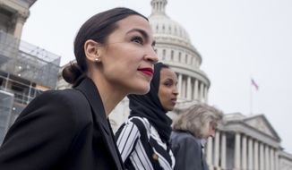 Rep. Alexandria Ocasio-Cortez, left, and D-N.Y., Rep. Ilhan Omar, D-Minn., center, walk down the House steps to take a group photograph of the House Democratic women members of the 116th Congress on the East Front Capitol Plaza on Capitol Hill in Washington, Friday, Jan. 4, 2019, as the 116th Congress begins. Also pictured is Rep. Dina Titus, D-Nev., right. (AP Photo/Andrew Harnik) **FILE**