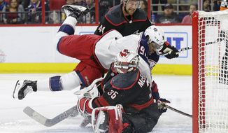 Carolina Hurricanes goalie Curtis McElhinney (35) blocks Columbus Blue Jackets&#39; Anthony Duclair (91) while Hurricanes&#39; Calvin de Haan (44) watches during the first period of an NHL hockey game in Raleigh, N.C., Friday, Jan. 4, 2019. (AP Photo/Gerry Broome)