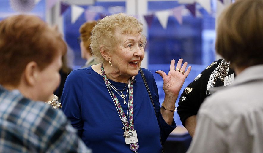 In this Wednesday, Dec. 12, 2018 photo, Lenore Lewis talks with friends and co-workers as she was honored for 61 years of service at the Salt Lake City Library in Salt Lake City. Lewis retired on Dec. 31. (Ravell Call/The Deseret News via AP)