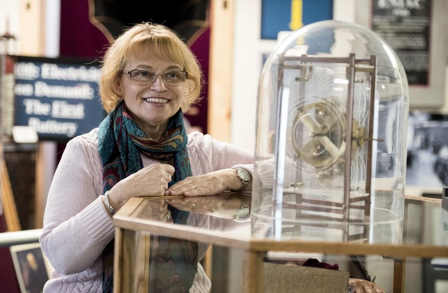 Barbara Keremedjiev poses for a photo next to a reproduction of an Antikythera Mechanism, an ancient Greek analog computer, Wednesday, Jan. 2, 2019, at the American Computer & Robotics Museum in Bozeman, Mont. The device was used by the Greeks to predict the movements of the planets and stars in the solar system. Keremedjiev recently reopened the museum after the passing of her husband, George Keremedjiev. (Shawn Raecke/Bozeman Daily Chronicle via AP)