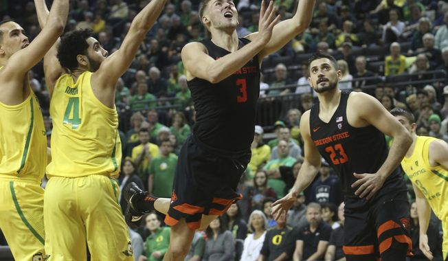 Oregon State&#x27;s Tres Tinkle, center, goes up to shoot between Oregon&#x27;s Paul White, left, Ehab Amin and teammate Gligorije Rakocevic, right, during the second half of an NCAA college basketball game Saturday, Jan. 5, 2019, in Eugene, Ore. (AP photo/Chris Pietsch)