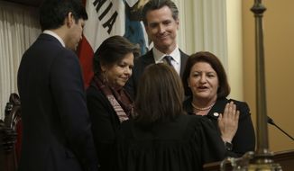 FILE- In this March 21, 2018 file photo, Lt. Gov. Gavin Newsom, second from right, watches as State Sen. Toni Atkins, D-San Diego, right, is sworn in as the new President Pro Tempore of the Senate by California Supreme Court Chief Justice Tani Cantil-Sakauye, second from right, at the Capitol, in Sacramento, Calif. Newsom,will be sworn-in to office Monday, Jan. 7, 2019, and will work with a Legislature firmly gripped by Democrats. (AP Photo/Rich Pedroncelli, File)