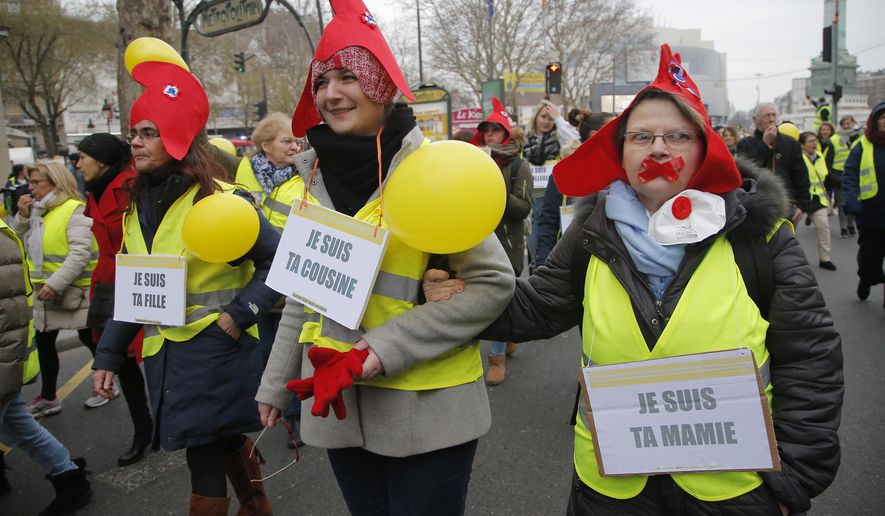 Women donning red bonnets , that symbolizes the French Revolution and wearing yellow vests march during a protest in Paris, Sunday, Jan. 6, 2019. Several hundred women wearing yellow vests march during a rally in Paris to give a different image to the movement. (AP Photo//Michel Euler)