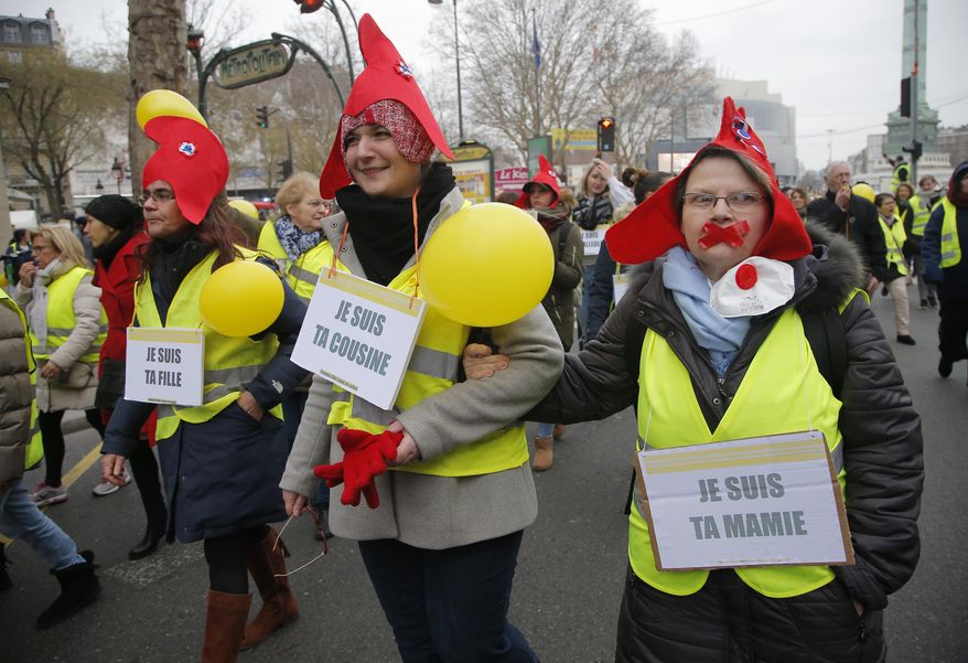Women donning red bonnets , that symbolizes the French Revolution and wearing yellow vests march during a protest in Paris, Sunday, Jan. 6, 2019. Several hundred women wearing yellow vests march during a rally in Paris to give a different image to the movement. (AP Photo//Michel Euler)