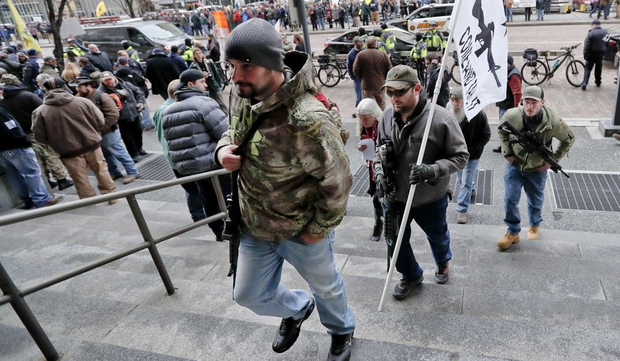 Protestors carrying rifles walk up the steps for a rally at the City County building on Monday, Jan. 7, 2019, in Pittsburgh. The protesters, many openly carrying guns, gathered in downtown Pittsburgh to rally against the city council's proposed restrictions and banning of semi-automatic rifles, certain ammunition and firearms accessories within city limits. (AP Photo/Keith Srakocic)
