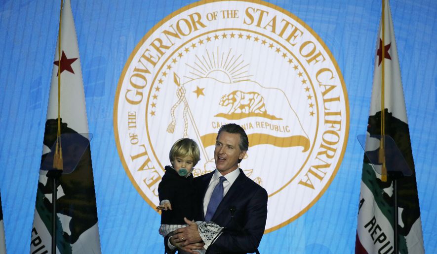 California Governor Gavin Newsom holds his son, Dutch, while speaking during his inauguration Monday, Jan. 7, 2019, in Sacramento, Calif. (AP Photo/Eric Risberg)