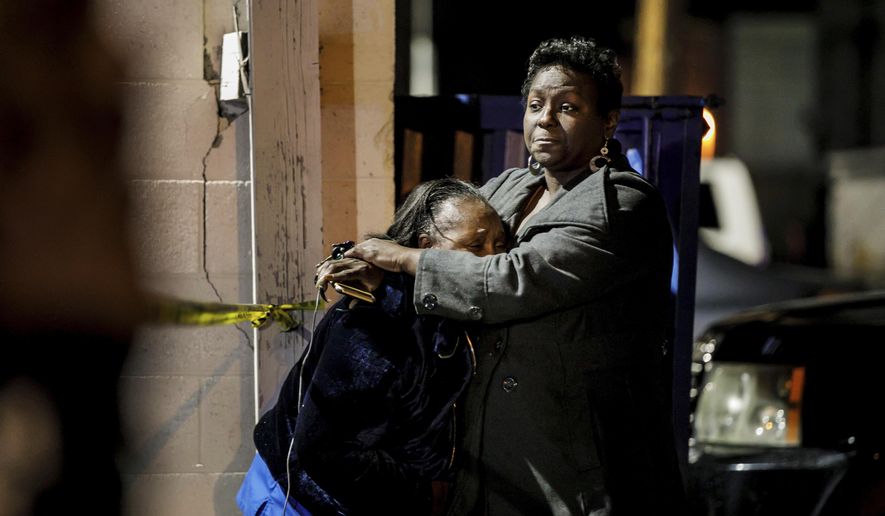 People hug and console each other at the scene of a shooting at the Gable House Bowl in Torrance, Calif., on Saturday, Jan. 5, 2019. Police responded shortly after midnight to calls of shots fired at the bowling ally. Several people were injured. (Marcus Yam/Los Angeles Times via AP)